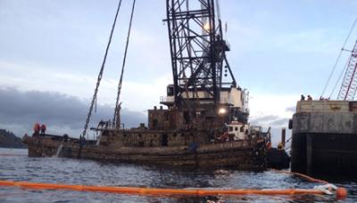 Now know as YTM-395, a former Navel Tug is pulled from the depth of Quartermaster Harbor by the Washing Department of Natural Resources. Photo by Troy Kindred